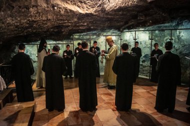 Kudüs, İsrail, 21 Şubat 2026 Katolik rahipler ve inananlar Kutsal Mezar 'ın karanlığında bir ayini kutluyorlar. Antik şehir tapınağındaki kutsal dua ve inanç atmosferi.