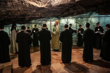 Kudüs, İsrail, 21 Şubat 2026 Katolik rahipler ve inananlar Kutsal Mezar 'ın karanlığında bir ayini kutluyorlar. Antik şehir tapınağındaki kutsal dua ve inanç atmosferi.