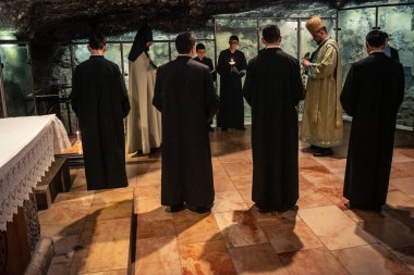 Kudüs, İsrail, 21 Şubat 2026 Katolik rahipler ve inananlar Kutsal Mezar 'ın karanlığında bir ayini kutluyorlar. Antik şehir tapınağındaki kutsal dua ve inanç atmosferi.