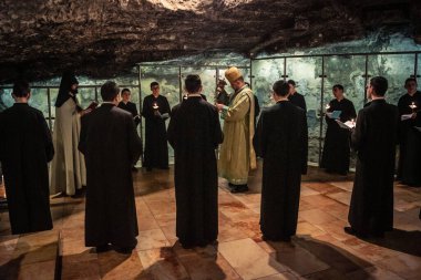 Kudüs, İsrail, 21 Şubat 2026 Katolik rahipler ve inananlar Kutsal Mezar 'ın karanlığında bir ayini kutluyorlar. Antik şehir tapınağındaki kutsal dua ve inanç atmosferi.