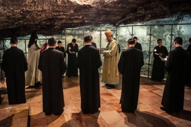 Kudüs, İsrail, 21 Şubat 2026 Katolik rahipler ve inananlar Kutsal Mezar 'ın karanlığında bir ayini kutluyorlar. Antik şehir tapınağındaki kutsal dua ve inanç atmosferi.