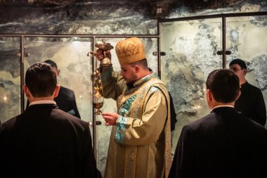 Kudüs, İsrail, 21 Şubat 2026 Katolik rahipler ve inananlar Kutsal Mezar 'ın karanlığında bir ayini kutluyorlar. Antik şehir tapınağındaki kutsal dua ve inanç atmosferi.