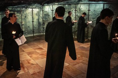 Kudüs, İsrail, 21 Şubat 2026 Katolik rahipler ve inananlar Kutsal Mezar 'ın karanlığında bir ayini kutluyorlar. Antik şehir tapınağındaki kutsal dua ve inanç atmosferi.