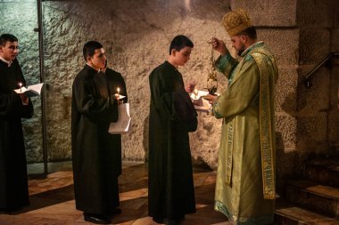 Kudüs, İsrail, 21 Şubat 2026 Katolik rahipler ve inananlar Kutsal Mezar 'ın karanlığında bir ayini kutluyorlar. Antik şehir tapınağındaki kutsal dua ve inanç atmosferi.