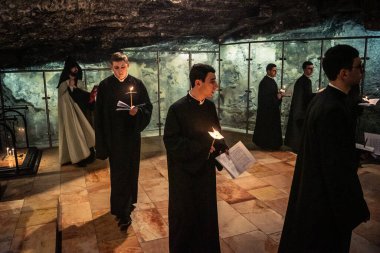 Kudüs, İsrail, 21 Şubat 2026 Katolik rahipler ve inananlar Kutsal Mezar 'ın karanlığında bir ayini kutluyorlar. Antik şehir tapınağındaki kutsal dua ve inanç atmosferi.