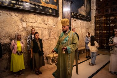 Kudüs, İsrail, 21 Şubat 2026 Katolik rahipler ve inananlar Kutsal Mezar 'ın karanlığında bir ayini kutluyorlar. Antik şehir tapınağındaki kutsal dua ve inanç atmosferi.