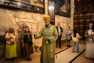 Kudüs, İsrail, 21 Şubat 2026 Katolik rahipler ve inananlar Kutsal Mezar 'ın karanlığında bir ayini kutluyorlar. Antik şehir tapınağındaki kutsal dua ve inanç atmosferi.