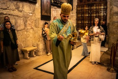 Kudüs, İsrail, 21 Şubat 2026 Katolik rahipler ve inananlar Kutsal Mezar 'ın karanlığında bir ayini kutluyorlar. Antik şehir tapınağındaki kutsal dua ve inanç atmosferi.