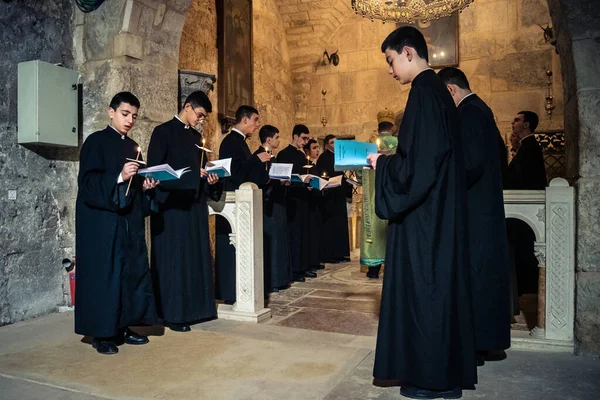 Kudüs, İsrail, 21 Şubat 2026 Katolik rahipler ve inananlar Kutsal Mezar 'ın karanlığında bir ayini kutluyorlar. Antik şehir tapınağındaki kutsal dua ve inanç atmosferi.