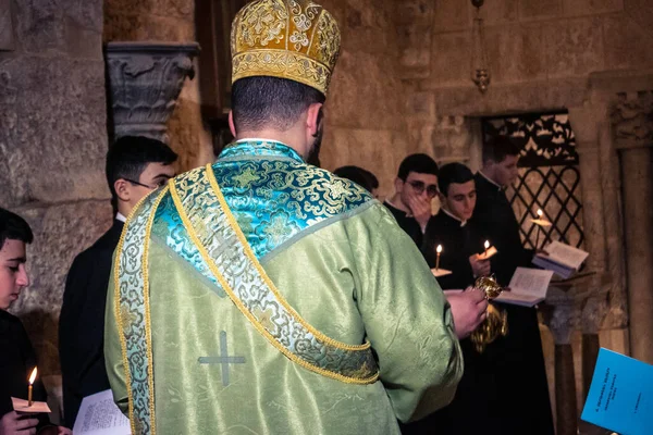 Kudüs, İsrail, 21 Şubat 2026 Katolik rahipler ve inananlar Kutsal Mezar 'ın karanlığında bir ayini kutluyorlar. Antik şehir tapınağındaki kutsal dua ve inanç atmosferi.