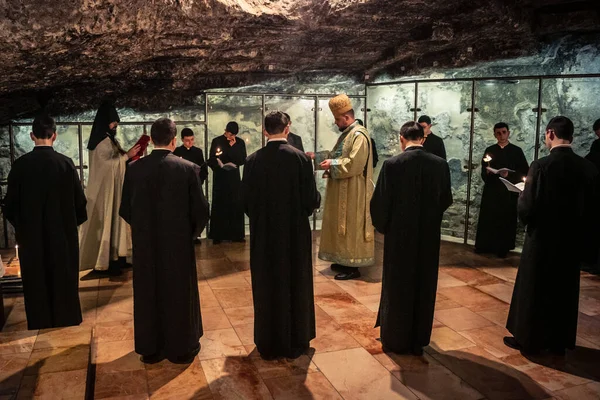 Kudüs, İsrail, 21 Şubat 2026 Katolik rahipler ve inananlar Kutsal Mezar 'ın karanlığında bir ayini kutluyorlar. Antik şehir tapınağındaki kutsal dua ve inanç atmosferi.