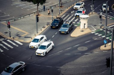 Tel Aviv, İsrail - 23 Şubat 2026: Şehir merkezinde yoğun bir kavşaktan geçen beyaz bir taksi. Şehir trafiği hafta içi Akdeniz Hitech metropolünün yüksek yoğunluk ve ekonomik faaliyetlerini yansıtıyor.