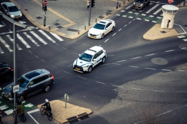 Tel Aviv, İsrail - 23 Şubat 2026: Şehir merkezinde yoğun bir kavşaktan geçen beyaz bir taksi. Şehir trafiği hafta içi Akdeniz Hitech metropolünün yüksek yoğunluk ve ekonomik faaliyetlerini yansıtıyor.