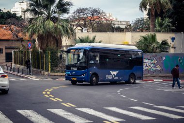 Tel Aviv, İsrail - 25 Şubat 2026: Modern bir elektrikli otobüs şehrin sokaklarından geçiyor. Tel Aviv, vatandaşlarına sürdürülebilir ve çevre dostu hareketlilik sağlamak için yeşil toplu taşıma ağını genişletiyor.