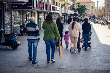 Tel Aviv, İsrail, 25 Şubat 2026, UR.A.C.I. 'ın gözlemlediği dinamik şehir hayatı akışı, sokakta yürüyen ve geçen insanlar. Bütünleşik Vicdan Robot Birimi.