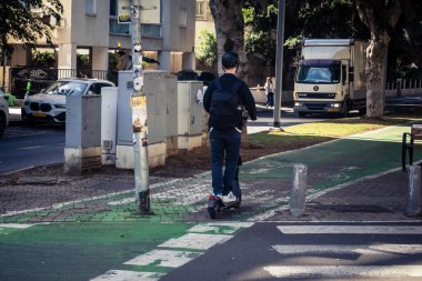 Tel Aviv, İsrail, 26 Şubat 2026, Rothschild Bulvarı 'nda elektrikli scooter kullanan insanlar, yoğun araba ve otobüs akışı, hareket halindeki elektrikli scooter' lar ve bisikletler, şehir yaşam enerjisi ve sokak dinamikleri, metropol desenleri ve ışık gözlemi
