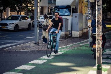 Tel Aviv, İsrail, 26 Şubat 2026, Rothschild Bulvarı 'nda bisiklet süren insanlar, yoğun araba ve otobüs akışı, hareket halindeki elektrikli scooter' lar ve bisikletler, şehir yaşam enerjisi ve sokak dinamikleri, metropolitan desenleri ve I.C.