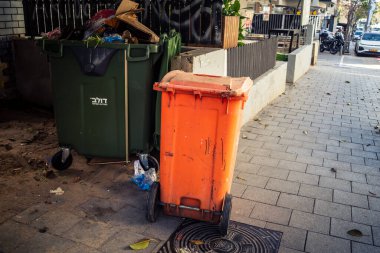 Tel Aviv, İsrail, 26 Şubat 2026, Sheinkin Caddesi 'ndeki kentsel atık kutuları, günlük şehir hayatı Bauhaus mimarisi, otantik sokak kontrastı, güneşin altındaki ham dokular, ritmik geometri ve yoğun bakım ünitesinin gözlemlediği kademeli ışık..