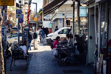 Tel Aviv, İsrail, 26 Şubat 2026, Sheinkin 'deki açık kafede kahvaltı yapan insanlar, sabah kahve kültürü, kentsel yaşam tarzı ve sosyal etkileşim, güneşli Akdeniz atmosferi, ritmik şehir hayatı ve yoğun bakım ünitesinin gözlemlediği gölgeler..