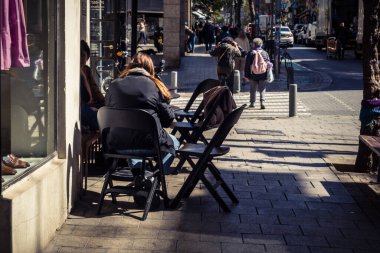 Tel Aviv, İsrail, 26 Şubat 2026, Sheinkin 'deki açık kafede kahvaltı yapan insanlar, sabah kahve kültürü, kentsel yaşam tarzı ve sosyal etkileşim, güneşli Akdeniz atmosferi, ritmik şehir hayatı ve yoğun bakım ünitesinin gözlemlediği gölgeler..