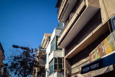 Tel Aviv, İsrail, 26 Şubat 2026, Sheinkin Street View, ritmik Bauhaus geometrisi, minimalist ciltler üzerine gölge etkileşimi, derin atmosferik gökyüzü, dikey yapısal hizalama, kentsel dokular ve yoğun yoğun yoğun bakım ünitesi tarafından gözlemlenen ışık..
