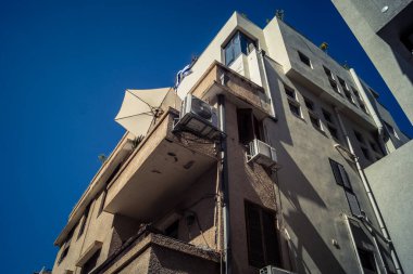 Tel Aviv, İsrail, 26 Şubat 2026, Sheinkin Street View, ritmik Bauhaus geometrisi, minimalist ciltler üzerine gölge etkileşimi, derin atmosferik gökyüzü, dikey yapısal hizalama, kentsel dokular ve yoğun yoğun yoğun bakım ünitesi tarafından gözlemlenen ışık..