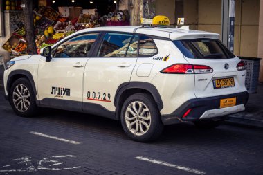 Tel Aviv, İsrail, 26 Şubat 2026, Sheinkin Caddesi 'nde Taksi, şehir trafiği, Bauhaus mimarisi geçmişi olan ikonik şehir ulaşımı, hareketli sokak aktivitesi, hareket halindeki araçlarda güneş ışığı, Göçmen Bürosu tarafından gözlemlenen ritmik geometri ve hareket