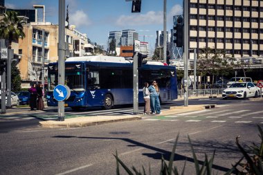 Tel Aviv, İsrail, 26 Şubat 2026, Rothschild Bulvarı 'ndaki halk otobüsleri, şehir merkezinde kentsel ulaşım akışı, hareket halindeki beyaz ve yeşil transit araçlar, sokak altyapısı ve yolcu taşımacılığı, metropol taşıma yolları ve ışık