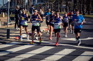 Tel Aviv, İsrail, 27 Şubat 2026 Yıllık maraton boyunca büyük bir koşucu topluluğu sokaklarda yarışıyor, binlerce katılımcı büyük spor etkinliğine katılıyor, kentsel yarış belgeleri ve yayın fotoğrafçılığı.