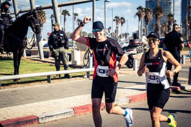 Tel Aviv, İsrail, 27 Şubat 2026 Bir katılımcı doğrudan göz teması kuruyor ve kameraya el sallıyor. Şehir maratonu sırasında kişisel bir bağlantı ve dayanıklılık anı yakalıyor..