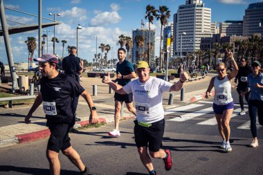 Tel Aviv, İsrail, 27 Şubat 2026 Bir katılımcı doğrudan göz teması kuruyor ve kameraya el sallıyor. Şehir maratonu sırasında kişisel bir bağlantı ve dayanıklılık anı yakalıyor..