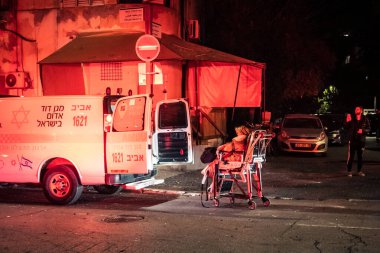 Tel Aviv, İsrail, 1 Mart 2026 Tel Aviv şehir merkezindeki bir füze sahasında acil durum ekipleri ve güvenlik güçlerinin görüntüsü, sağlık görevlileri ve itfaiyeciler enkaz ve parçalanmış camlar arasında yardım sağlıyorlar.