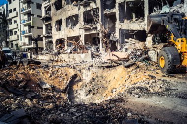 Tel Aviv, İsrail, 1 Mart 2026. Tel Aviv şehir merkezindeki bir füze saldırısından bir gün sonra belediye çalışanları ve sakinleri enkaz ve cam kırıkları arasında meydana gelen hasarları değerlendirerek bölgede güvenlik çemberi oluşturulmaya başlandı..