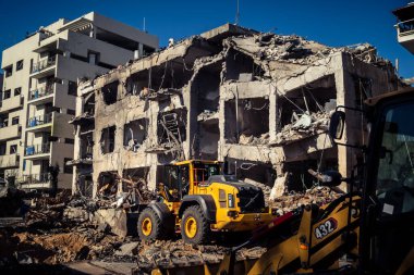 Tel Aviv, İsrail, 1 Mart 2026. Tel Aviv şehir merkezindeki bir füze saldırısından bir gün sonra belediye çalışanları ve sakinleri enkaz ve cam kırıkları arasında meydana gelen hasarları değerlendirerek bölgede güvenlik çemberi oluşturulmaya başlandı..