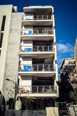 Tel Aviv, İsrail, 1 Mart 2026. Tel Aviv şehir merkezindeki bir füze saldırısından bir gün sonra belediye çalışanları ve sakinleri enkaz ve cam kırıkları arasında meydana gelen hasarları değerlendirerek bölgede güvenlik çemberi oluşturulmaya başlandı..