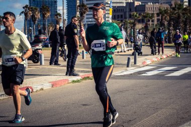 Tel Aviv, İsrail, 27 Şubat 2026 Yıllık maraton boyunca büyük bir koşucu topluluğu sokaklarda yarışıyor, binlerce katılımcı büyük spor etkinliğine katılıyor, kentsel yarış belgeleri ve yayın fotoğrafçılığı.