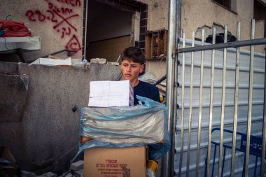 Tel Aviv, İsrail, 4 Mart 2026 Sivil gönüllüler füzenin düşüşünden sonra cam ve beton enkazı temizleme, toplum dayanışması ve acil yeniden yapılanma çabaları.