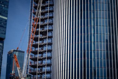 Tel Aviv, İsrail, 6 Mart 2026 Tel Aviv 'de inşaat halindeki yüksek katlı bir binanın zemin manzarası iskelet çeliği ve vinçler Kaplan-Begin kavşağı yakınlarında gökyüzüne karşı. Güvenlik güçleri devriye gezerken görülüyor.