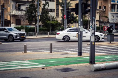 Tel Aviv, İsrail, 7 Mart 2026 Tel Aviv şehir trafiğinde ilerleyen profesyonel bir beyaz taksi aracı..