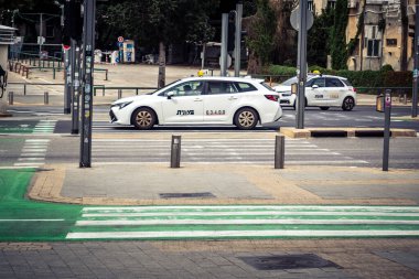 Tel Aviv, İsrail, 7 Mart 2026 Tel Aviv şehir trafiğinde ilerleyen profesyonel bir beyaz taksi aracı..