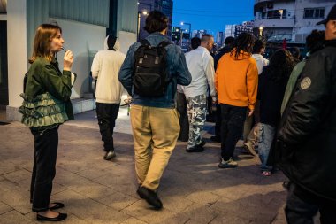Tel Aviv, İsrail, 9 Mart 2026 'da vatandaşlar Tel Aviv metro istasyonunun güçlendirilmiş yeraltı katlarında güvenlik önlemleri alınarak bomba sığınağına dönüştürülmesini bekliyorlar. Siviller yürüyen merdivenlerin yanında toplanır ve İbranice işaretleri takip ederek sa 'yı korurlar.