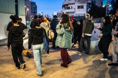 Tel Aviv, İsrail, 9 Mart 2026 'da vatandaşlar Tel Aviv metro istasyonunun güçlendirilmiş yeraltı katlarında güvenlik önlemleri alınarak bomba sığınağına dönüştürülmesini bekliyorlar. Siviller yürüyen merdivenlerin yanında toplanır ve İbranice işaretleri takip ederek sa 'yı korurlar.