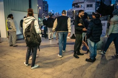 Tel Aviv, İsrail, 9 Mart 2026 'da vatandaşlar Tel Aviv metro istasyonunun güçlendirilmiş yeraltı katlarında güvenlik önlemleri alınarak bomba sığınağına dönüştürülmesini bekliyorlar. Siviller yürüyen merdivenlerin yanında toplanır ve İbranice işaretleri takip ederek sa 'yı korurlar.