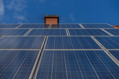 Bir evin kırmızı çatısındaki güneş panelleri. Güneş paneli, fotovoltaik, alternatif elektrik kaynağı - sürdürülebilir kaynaklar kavramı. Çevre dostu elektrik kaynağı.