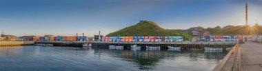 Hummerbuden tipik renkli evler akşamları Helgoland adasında, Schleswig-Holstein, Almanya 'da. Hummerbuden manzaralı ve güneşli liman manzaralı Panorama.