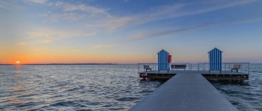 Gün batımında bulutlu gökyüzüne karşı deniz manzarası. Rıhtım Stein (Baltık Denizi), Probstei, Schleswig-Holstein, Almanya.