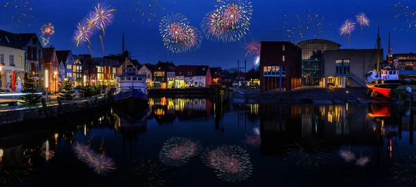 Fireworks, festive lighting and Sylvester romantic atmosphere in Husum at night. Nighttime view of Husum at Silvester time. Maritime Sylvester city.