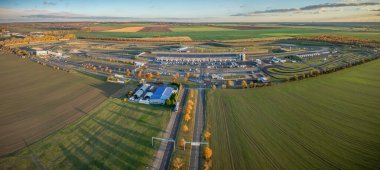 Tarım alanları ve açık kırsal alanlarla çevrili büyük motorsporları yarış pisti kompleksinin panorama hava görüntüsü. Birden fazla devresi, park alanı ve destek binaları olan yarış pisti..