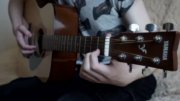 Khmelnytskyi, Ucrania - Abril 2021: Vista de cerca hombre irreconocible sosteniendo la guitarra acústica Yamaha sentado en casa solo. — Vídeo de stock