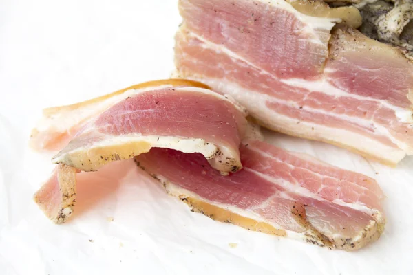 Du bacon salé, un morceau de papier couché sur le — Photo